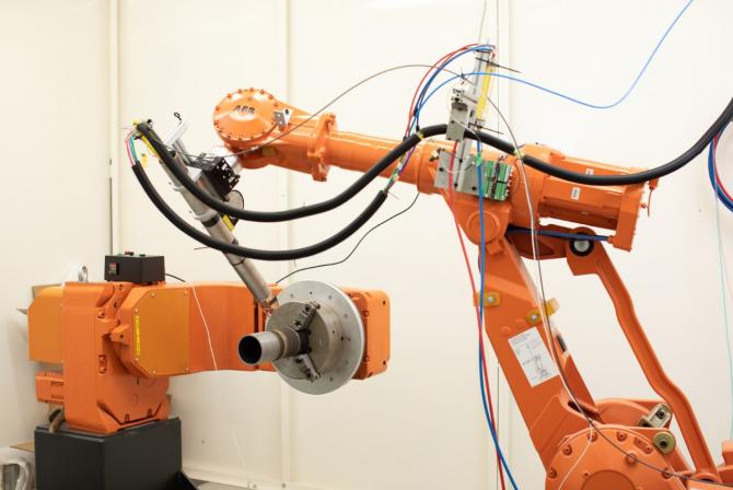 Deux bras robotiques en vis-à-vis avec plusieurs câbles électriques connectés