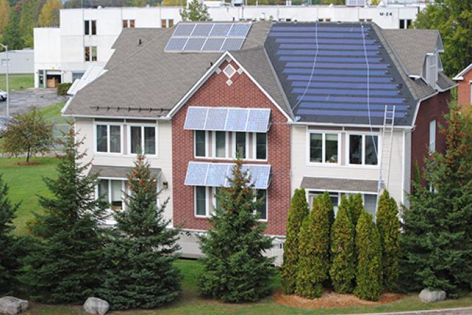 Vue aérienne d’un immeuble résidentiel à plusieurs logements avec panneaux solaires sur la toiture