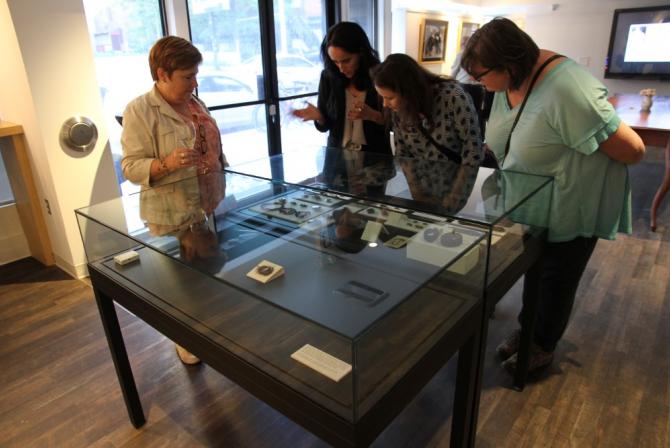 4 people viewing items in a glass display 