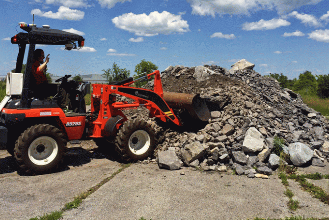 Person stacking rocks with a loader
