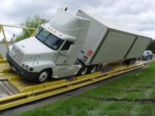 A tractor trailer on top of an outdoor vehicle ramp at an incline 