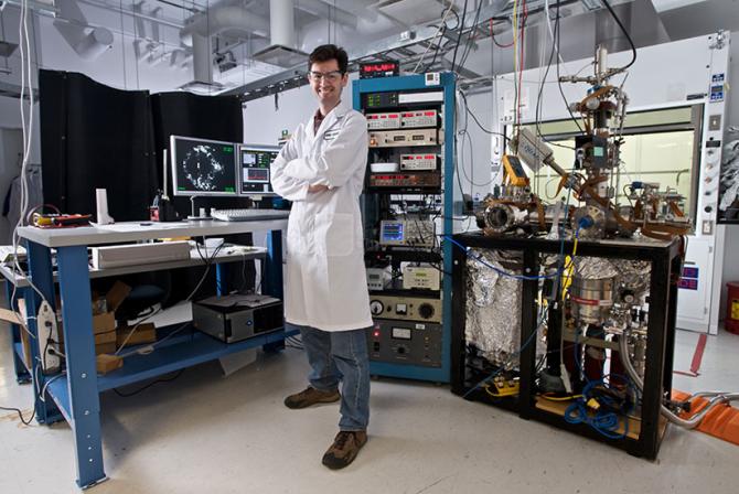 Researcher standing in a laboratory in front of microscopy instruments