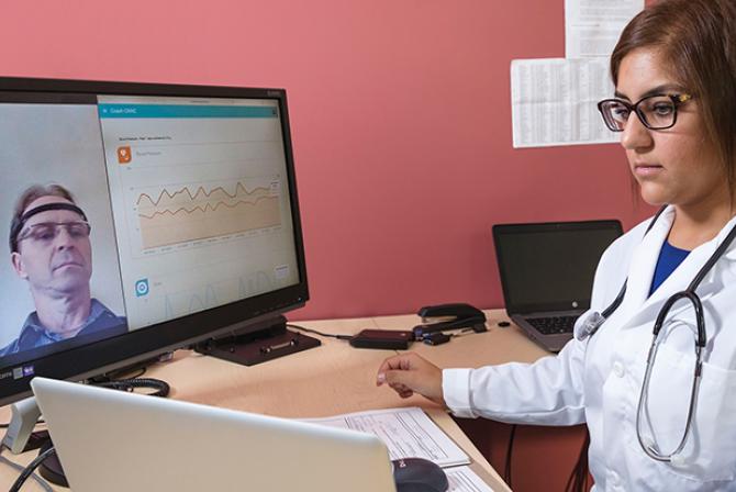 Researcher testing interactive software displaying remote patient data