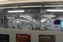 Facility name "Water Quality Centre" on a glass wall of the centre. The facility and equipment can be seen through the glass.