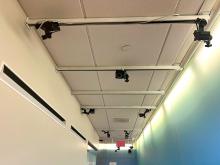 A series of cameras mounted on the ceiling in a hallway.